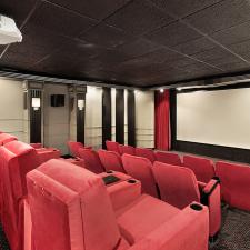 Home theater in luxury home with red chairs